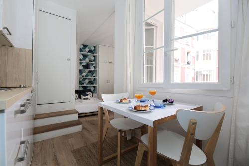 une salle à manger blanche avec une table et des chaises blanches dans l'établissement Studio original et reposant - Paris 10 - 2P, à Paris