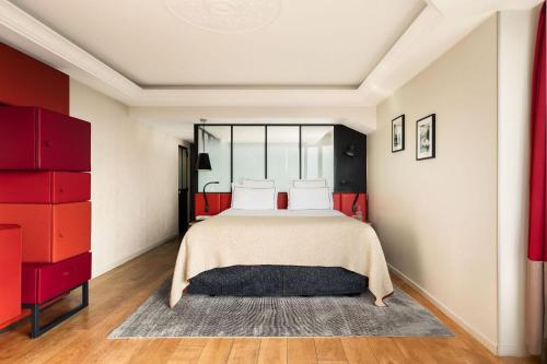a bedroom with a large bed with red cabinets at Terrass" Hotel in Paris