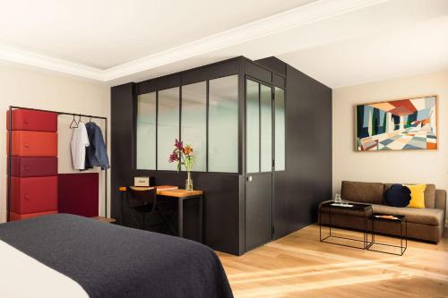 a bedroom with a large black cabinet and a couch at Terrass" Hotel in Paris