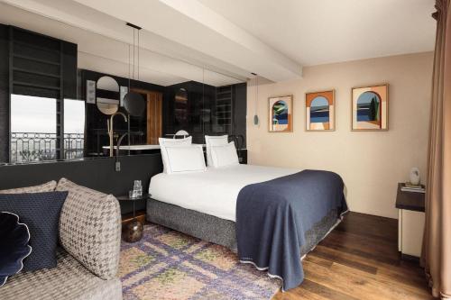 a bedroom with a large bed and a couch at Terrass" Hotel in Paris