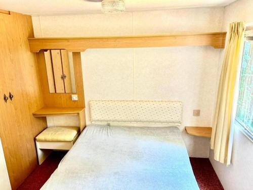 a small room with a bed and a window at Your Camp Kormoran Domek Holender in Hel