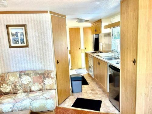 a small kitchen with a couch and a sink at Your Camp Kormoran Domek Holender in Hel
