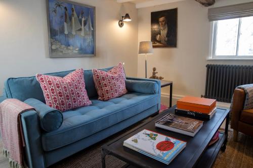 a living room with a blue couch and a table at Peckforton cottage totally refurbished in Beeston