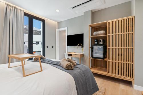 a bedroom with a bed with a table and a desk at Las Dunas de Santa Catalina Boutique House in Las Palmas de Gran Canaria