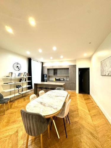 une cuisine et une salle à manger avec une table et des chaises dans l'établissement Appartements Auteuil Paris 16, à Paris