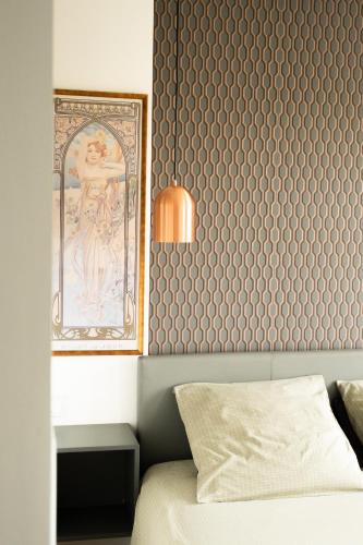 a bedroom with a wall with a painting and a bed at Villa Bel-Amy in Saint-Pair-sur-Mer