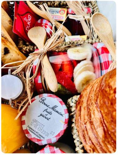 a basket of food with bread and other snacks at Authentique bergerie en pierre avec jacuzzi piscine et massages La grange des amoureux in Le Beausset