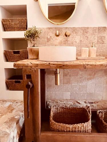a bathroom with a sink and a mirror at Authentique bergerie en pierre avec jacuzzi piscine et massages La grange des amoureux in Le Beausset