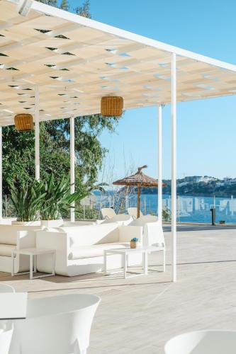 a pavilion with white furniture and a view of the ocean at Bahia Principe Escape Coral Playa Adults Only in Magaluf