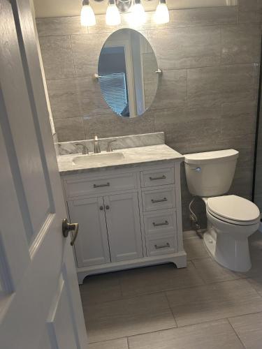 a bathroom with a toilet and a sink and a mirror at Greenlinks Naples Florida Condo in Naples