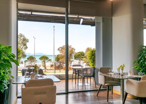 a restaurant with tables and chairs and sliding glass doors at Yacht Hotel in Vlorë
