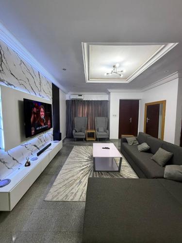 a living room with a couch and a tv at 1 bedroom Shortlet Apt at Osapa London Lekki in Lagos