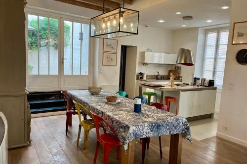 une cuisine avec une table et des chaises et une cuisine avec une table dans l'établissement Family home Saint Martin de Ré intra-muros, à Saint-Martin-de-Ré