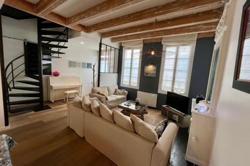 un salon avec un canapé et un escalier dans l'établissement Family home Saint Martin de Ré intra-muros, à Saint-Martin-de-Ré