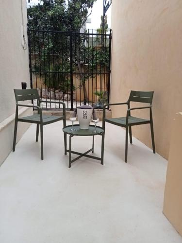 two chairs and a table in front of a gate at Scopelos in Scopello