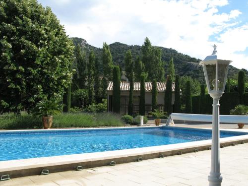 - une piscine en face d'une maison avec une lampe dans l'établissement Maison en PROVENCE, à Robion