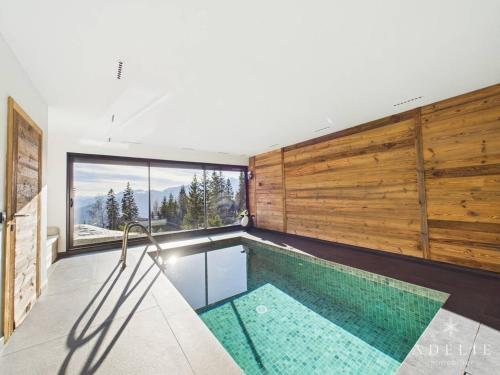 - une piscine dans une maison avec une grande fenêtre dans l'établissement Luxueux chalet avec piscine, sauna et parking à La Rosière pour 10 personnes - FR-1-398-633, à Montvalezan