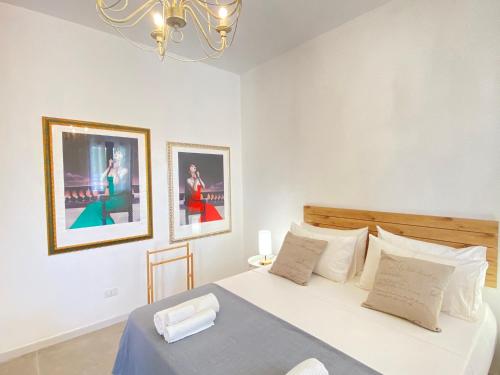 a bedroom with a bed with two pictures on the wall at Symphony Sound Villa with Pool in Chiesanuova