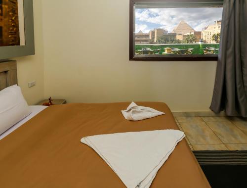 a bedroom with a bed and a window with a view at ATLAS pyramids VIEW in Cairo