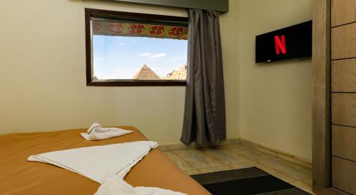 a bedroom with a bed and a window with the pyramid at ATLAS pyramids VIEW in Cairo