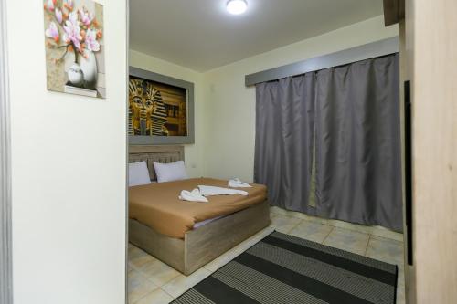 a small bedroom with a bed and a window at ATLAS pyramids VIEW in Cairo