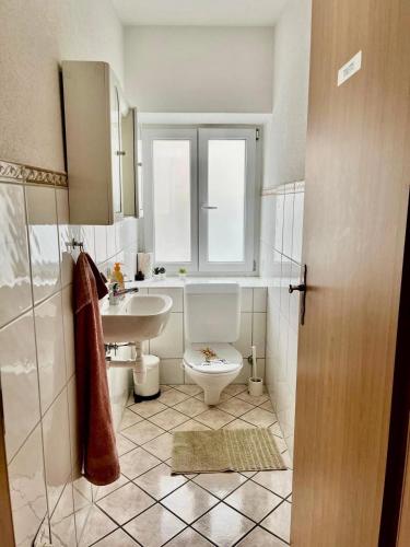 a bathroom with a toilet and a sink and a window at Suhr House in Suhr