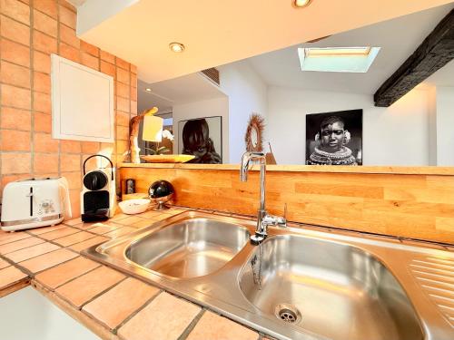 une cuisine avec un évier et un plan de travail dans l'établissement Charmant Appartement à 50m du Palais des Festivals et de la Croisette, à Cannes