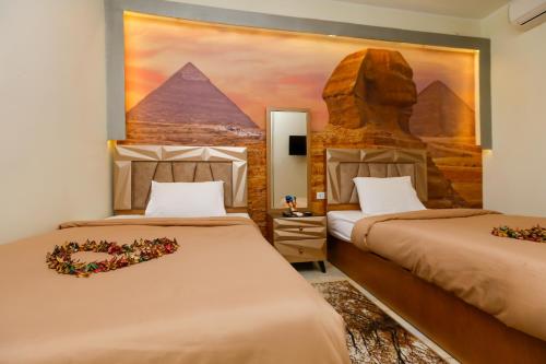 a hotel room with two beds and a painting on the wall at ATLAS pyramids VIEW in Cairo