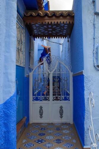 a blue room with a door with a person standing behind it at Casa Sanae in Chefchaouene
