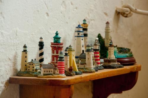 a group of miniature buildings on a wooden shelf at Dar tal-Kaptan Boutique Maison in Għasri