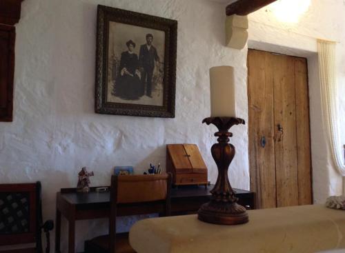 a room with a table with a lamp and a picture on the wall at Dar tal-Kaptan Boutique Maison in Għasri