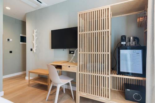 a room with a desk with a computer and a television at Las Dunas de Santa Catalina Boutique House in Las Palmas de Gran Canaria