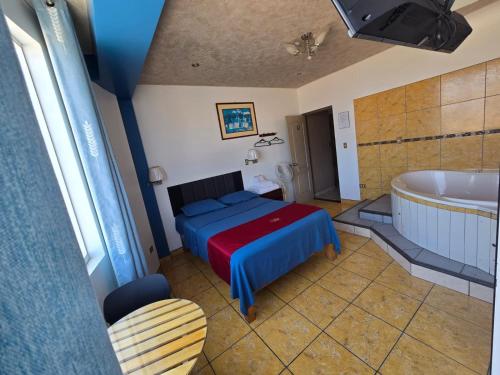 a bedroom with a bed and a bathtub and a tub at Hotel los angeles in Huaral