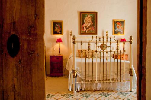 a bedroom with a bed and a table with a lamp at Dar tal-Kaptan Boutique Maison in Għasri