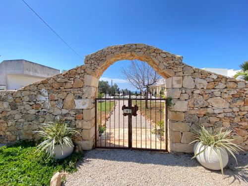 a gate in a stone wall with two potted plants at Symphony Sound Villa with Pool in Chiesanuova