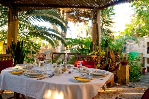 a table with a white table cloth and plates on it at Dar tal-Kaptan Boutique Maison in Għasri
