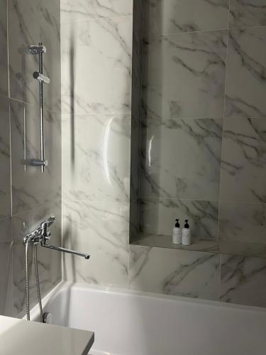 ein weißes Badezimmer mit Badewanne und Waschbecken in der Unterkunft Premium Plaza in Aqtau