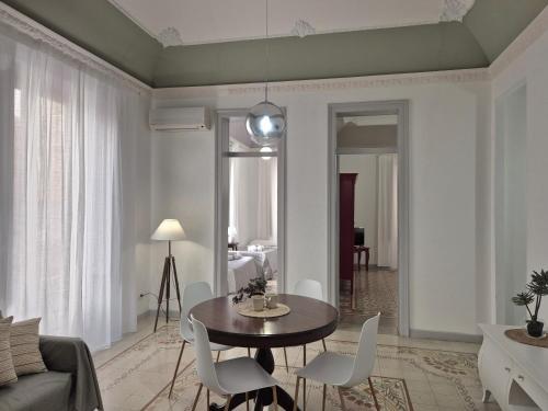a living room with a table and white chairs at La Mattanza in Trapani