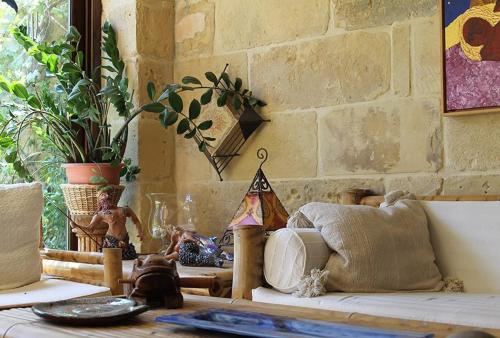 a living room with a couch and a brick wall at Dar tal-Kaptan Boutique Maison in Għasri
