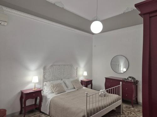 a white bedroom with a bed and two night stands at La Mattanza in Trapani