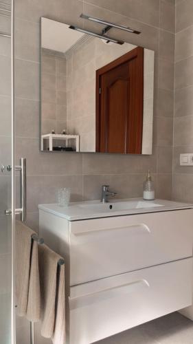 a bathroom with a white sink and a mirror at Villa Lila - planta 1ª in Pontevedra