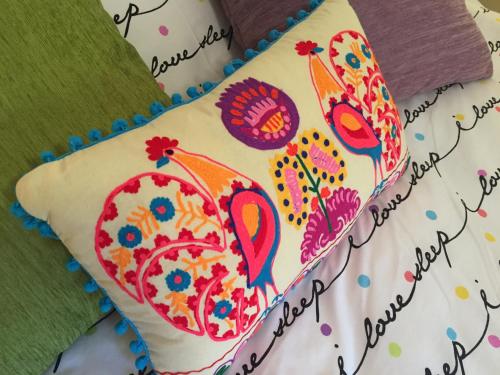 a pillow with a painting of two birds on it at Dar tal-Kaptan Boutique Maison in Għasri