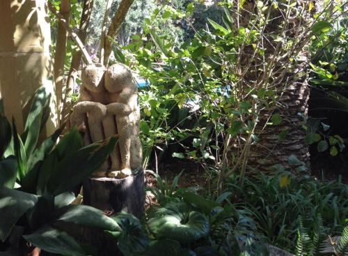 a statue of two people sitting on a stump in a garden at Dar tal-Kaptan Boutique Maison in Għasri