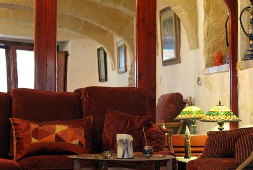 a living room with a couch and a table at Dar tal-Kaptan Boutique Maison in Għasri