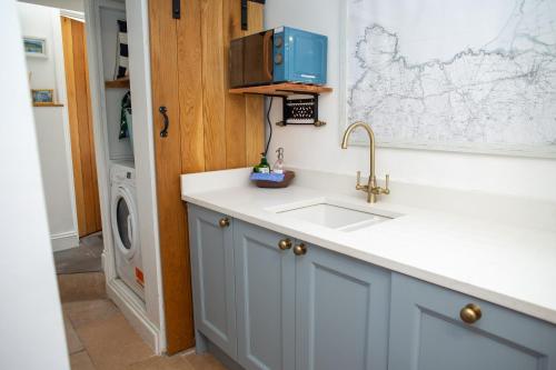 a kitchen with a sink and a washing machine at Y Bwthyn Newport, Pembrokeshire in Newport Pembrokeshire