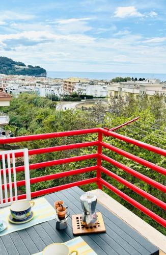 a table on a balcony with a red fence at Casa Vista Serapo in Gaeta