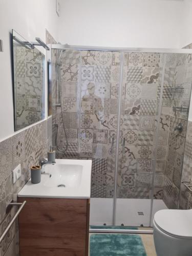a bathroom with a shower with a sink and a toilet at Le case del Borgo - Marzamemi in Marzamemi
