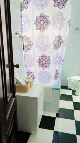 a bathroom with a shower curtain and a toilet at Casa Nieves, totalmente equipada Planta 2 in Arcos de la Frontera