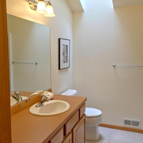 a bathroom with a sink and a toilet and a mirror at Mt Baker Rim Cabin 70 A pet friendly vacation home with a hot tub and wifi in Deming