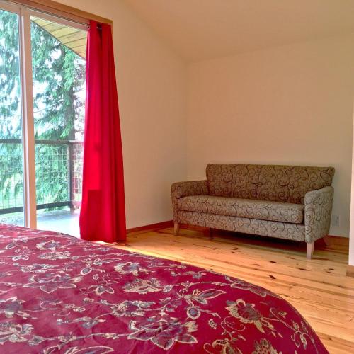 a bedroom with a bed and a couch and a window at Mt Baker Rim Cabin 70 A pet friendly vacation home with a hot tub and wifi in Deming